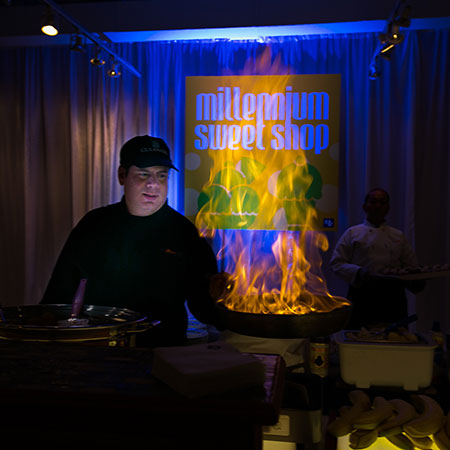 Chef Oldham with a flaming pan at a chef performance station