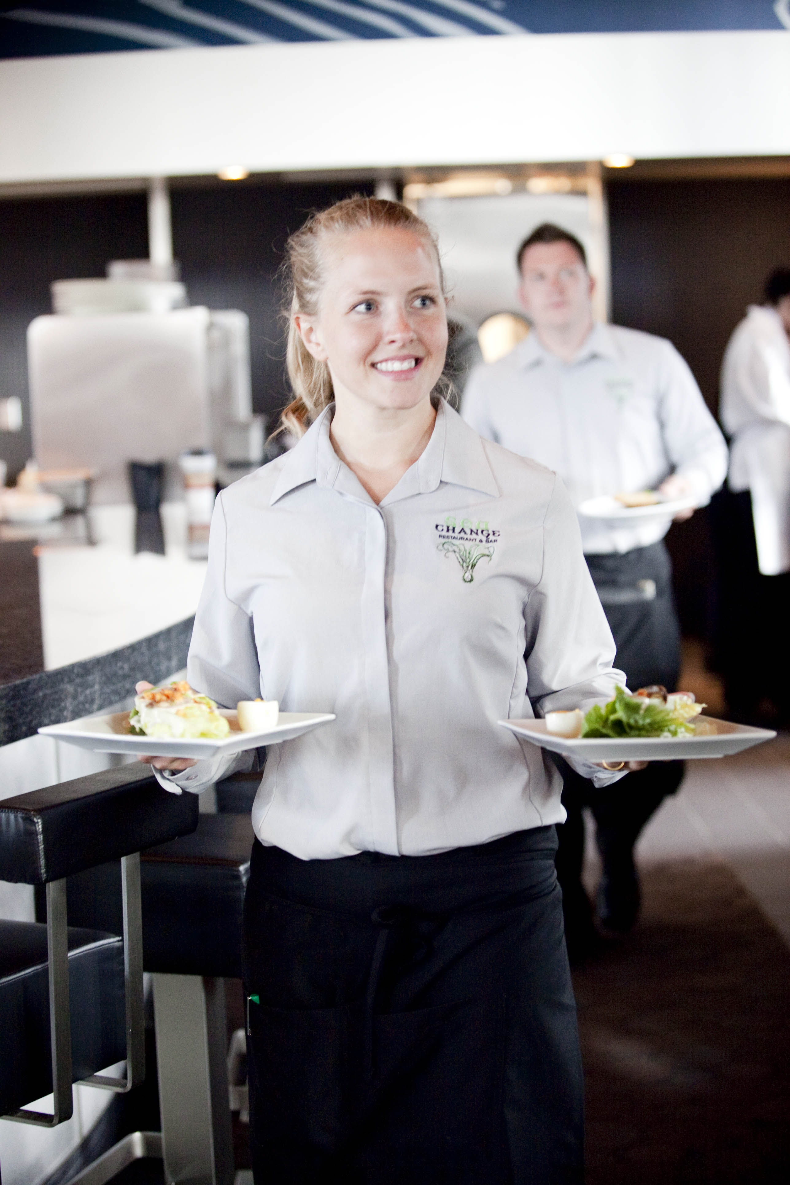 Smiling server bringing food to a table